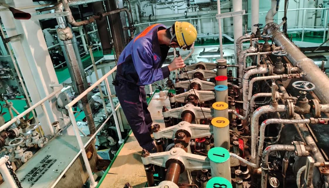 エンジンのシリンダーヘッドを点検する技術者