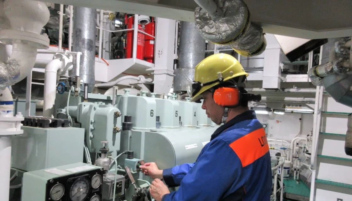 エンジンルームで計器を確認するエンジニア