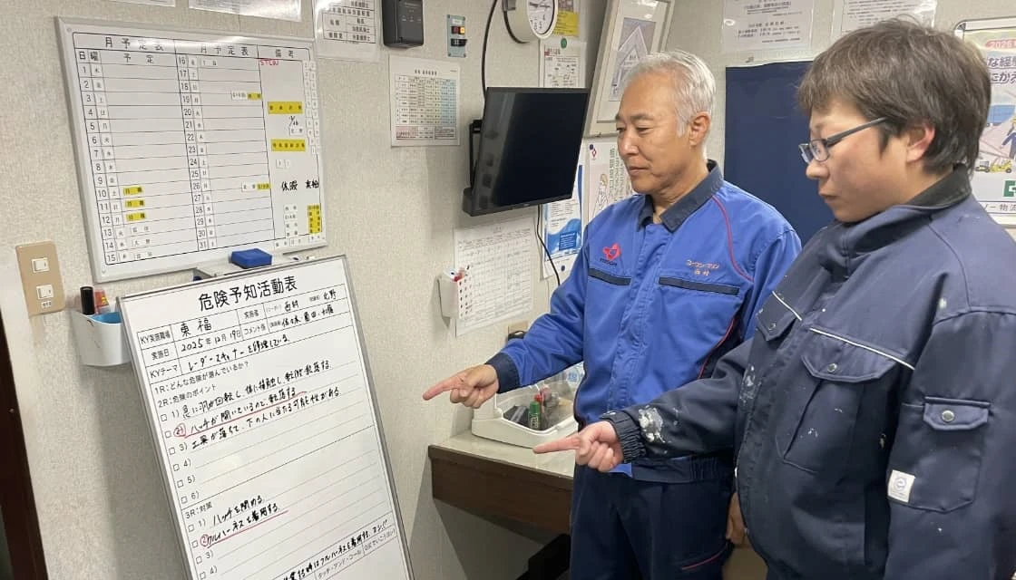 危険予知活動表を確認する2人の作業員