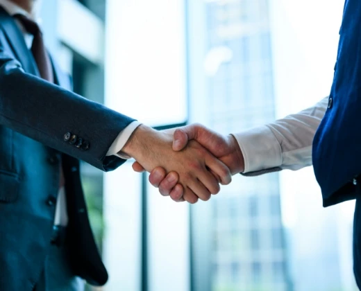 ビジネススーツを着た二人による信頼の握手