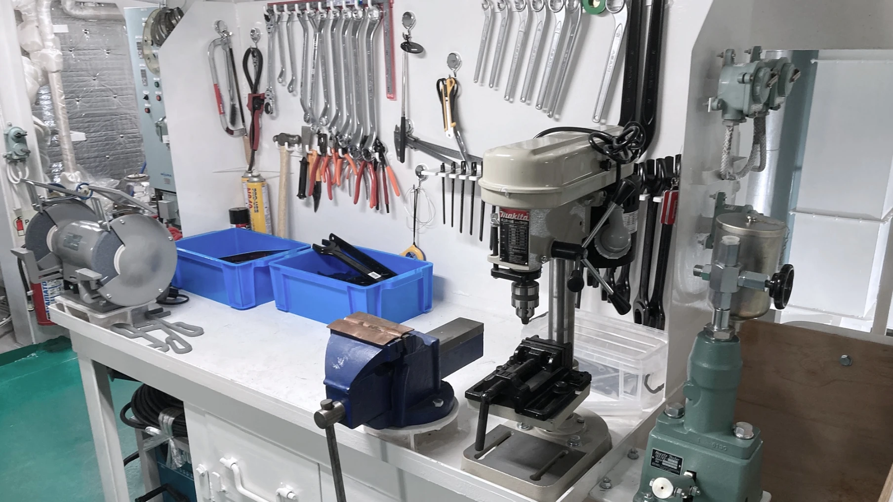 整理整頓された船内の工作機械と壁に掛けられた工具一式