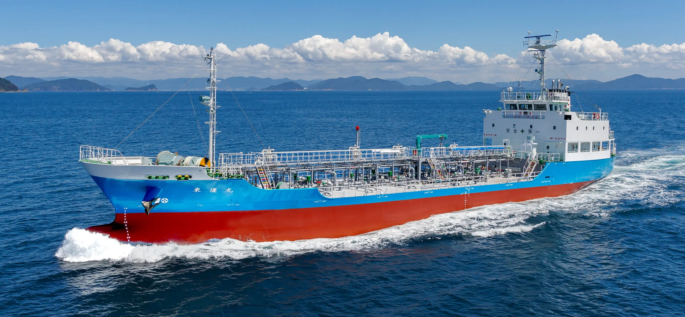 青空の下を航行するケミカルタンカーの全景